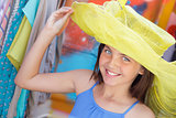 Pretty Girl Tries on Yellow Hat at Market