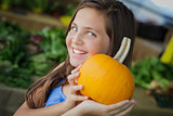 Pretty Young Girl Having Fun with the Pumpkins at Market