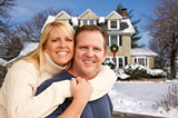 Couple in Front of Beautiful House with Snow on Ground