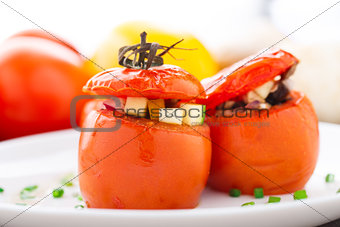 Three stuffed tomatoes on a white plate