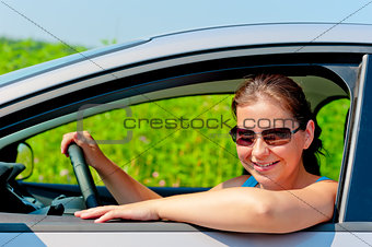 woman in sunglasses driving a modern car