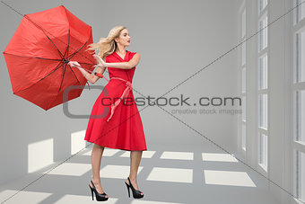 Composite image of beautiful woman posing with a broken umbrella