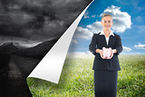 Composite image of happy businesswoman holding a piggy bank