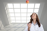 Composite image of happy doctor throwing apple