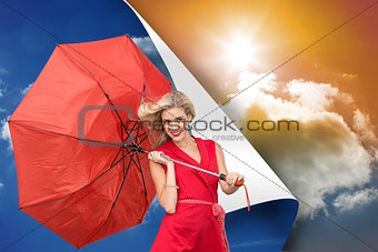 Composite image of smiling blonde holding umbrella