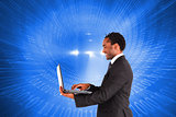 Composite image of businessman working on laptop