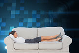 Composite image of smiling business woman lying down on the couch