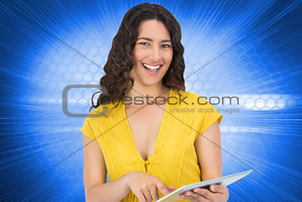 Composite image of smiling casual young woman scrolling on her tablet computer