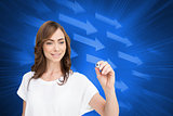 Composite image of smiling businesswoman holding marker