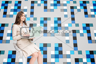Composite image of smiling businesswoman sitting and using laptop