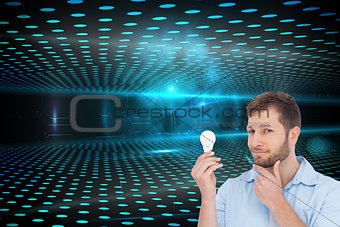 Composite image of handsome model holding a bulb