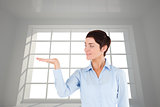 Composite image of businesswoman with an open hand to show a copy space