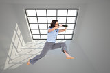 Composite image of cheerful classy businesswoman jumping while holding binoculars