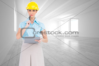 Composite image of thoughtful attractive architect holding clipboard