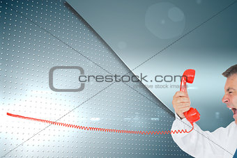 Composite image of businessman screaming directly into the handset