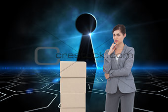 Composite image of thoughtful businesswoman posing with cardboard boxes