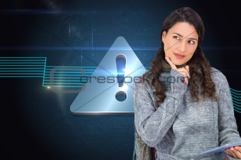 Composite image of pensive model wearing winter clothes holding her tablet