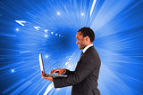 Composite image of businessman working on laptop