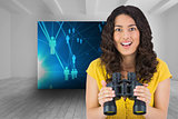 Composite image of smiling casual young woman holding binoculars