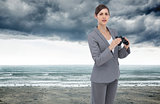 Composite image of curious young businesswoman posing with binoculars