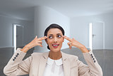 Composite image of confident young businesswoman pointing her head with her fingers