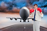 Composite image of businessman with his boxing gloves ready to fight