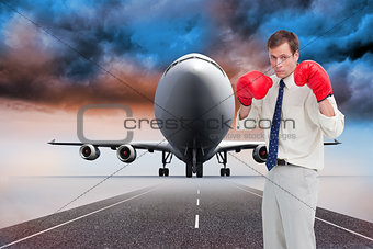 Composite image of businessman with his boxing gloves ready to fight
