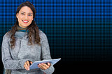 Composite image of smiling model wearing winter clothes holding her tablet