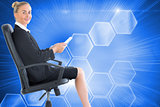 Composite image of businesswoman sitting in swivel chair holding folder