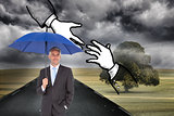 Composite image of businessman smiling at camera and holding blue umbrella