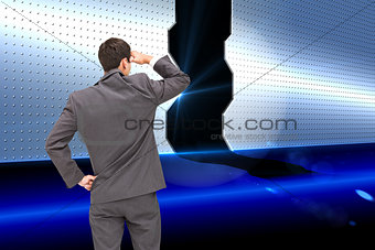 Composite image of businessman standing hand on hip