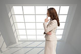 Composite image of profile view of doubtful businesswoman standing