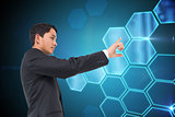 Composite image of serious asian businessman pointing