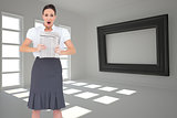 Composite image of shocked stylish businesswoman holding newspaper