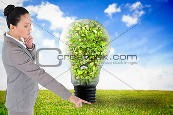 Composite image of unsmiling thinking asian businesswoman pointing