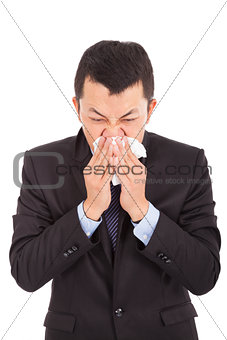 sick young businessman is sneezing with toilet paper 