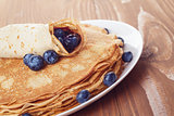 homemade blinis or crepes with blueberries and jam toned photo