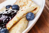 homemade blinis or crepes with blueberries and jam