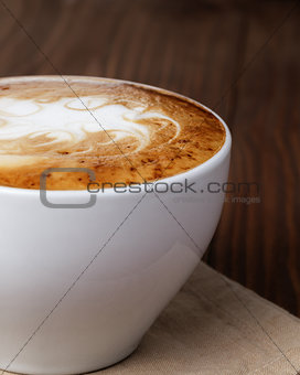 freshly made cup of cappuccino with abstract latte art