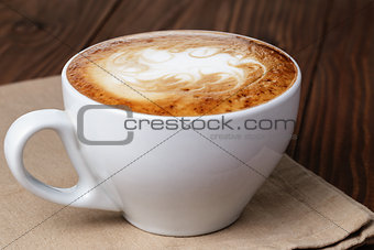 freshly made cup of cappuccino with abstract latte art