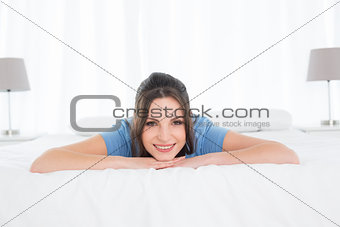 Portrait of a pretty happy woman resting in bed