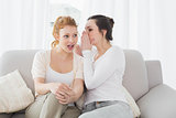 Relaxed female friends gossiping in living room