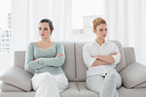 Unhappy friends not talking after argument on the couch