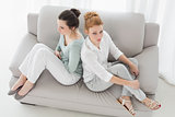 Unhappy female friends not talking after argument on the couch
