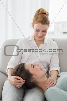Female resting on friends lap in the living room