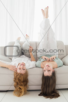 Female friends lying on sofa in the living room