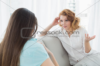 Female friends sitting on sofa in the living room