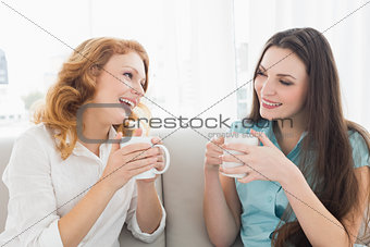 Female friends with coffee enjoying a conversation at home
