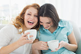 Friends with coffee cups enjoying a conversation at home