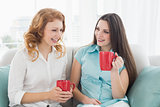 Friends with coffee cups conversing at home